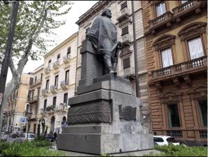 uma estátua de um homem parado em frente a um edifício em Moonlight Hotel&Suites em Catânia