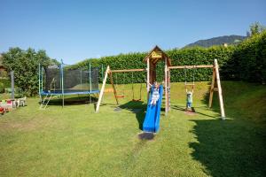 two children playing on a swing set in a yard at Appartement Unterbering in Söll