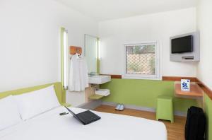 - une chambre avec un lit et un ordinateur portable dans l'établissement ibis Budget - Newcastle, à Newcastle