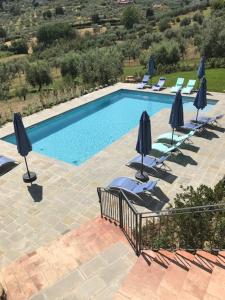 een zwembad met stoelen en parasols bij Agriturismo San Martino in Quarrata