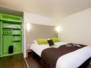 una camera d'albergo con un letto e un computer portatile di Campanile Saint-Quentin-En-Yvelines a Montigny-le-Bretonneux