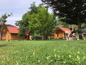 a woman sitting on a bench with a sheep at Camp Podgrad Vransko in Vransko