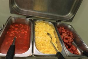 dos bandejas metálicas de comida con frijoles y tomates en Turis Hotel Centro, en Campo Grande