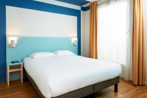 A bed or beds in a room at Aparthotel Adagio Access Strasbourg Illkirch