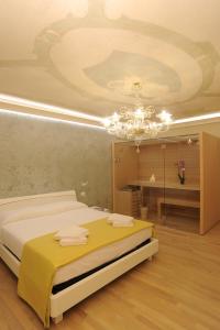 um quarto com uma cama e um lustre em CA' XXII MARZO BOUTIQUE em Veneza