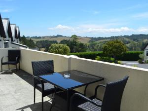 een tafel en stoelen op een balkon met uitzicht bij Salty Dog Inn in Snells Beach