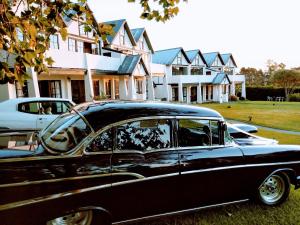 een zwart-witte auto geparkeerd voor de huizen bij Salty Dog Inn in Snells Beach