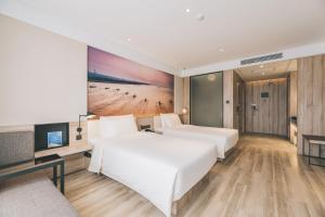 een hotelkamer met 2 bedden en een televisie bij Atour Hotel Haining Leather City South Gate in Haining