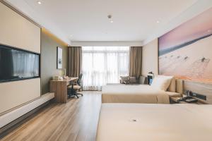 een hotelkamer met 2 bedden en een flatscreen-tv bij Atour Hotel Haining Leather City South Gate in Haining