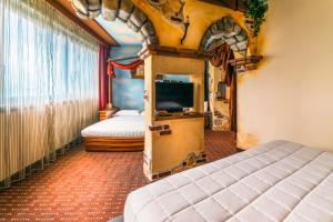 a bedroom with two beds and a tv in a room at Grand Hotel Mattei in Ravenna