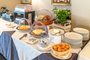 a buffet with plates and bowls of food on a table at Grand Hotel Mattei in Ravenna