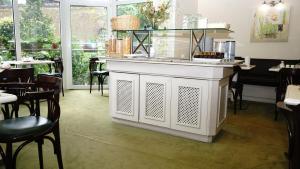 a white counter in a restaurant with tables and chairs at Entrée Groß Borstel Garni Hotel in Hamburg