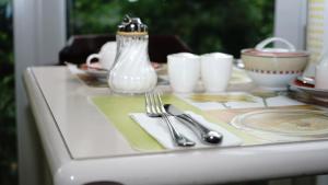 a table with silverware and a glass vase on it at Entrée Groß Borstel Garni Hotel in Hamburg