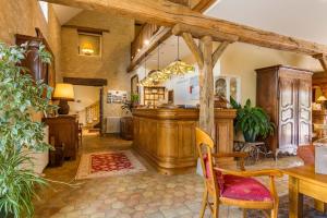 een woonkamer met een tafel en een bar bij Hôtel Le Clos in Montagny-lès-Beaune