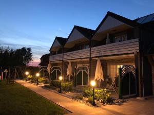 un edificio con sombrillas delante de él por la noche en Haus Daniel, en Neuharlingersiel