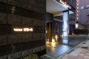 a building with a sign on the side of it at Dormy Inn Premium Kyoto Ekimae Natural Hot Spring in Kyoto