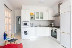 cocina con armarios blancos y lavadora en Apartamento Orlando - Costa Adeje, en Adeje