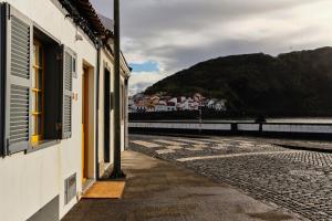 un edificio con finestra e vista sull'acqua di Casinha Pim a Horta