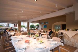 un restaurante con mesas blancas y gente sentada en ellas en Hotel Nibaru, en Porto Cervo