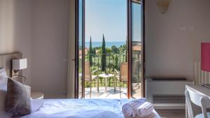 - une chambre avec un lit et une vue sur un balcon dans l'établissement Hotel Relais Agli Olivi, à Lazise