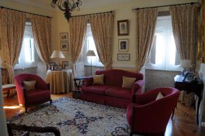 a living room with a red couch and two chairs at Casa De Fatauncos in Vouzela