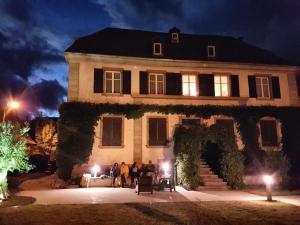 a group of people standing in front of a house at night at Ancien Presbytère Albert Schweitzer in Gunsbach