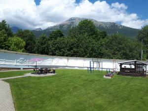 un parque con un parque infantil con una montaña al fondo en A1 Štart, en Starý Smokovec