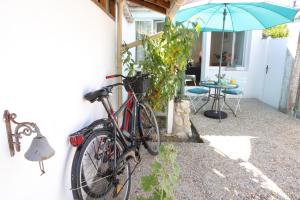 un vélo garé sur le côté d'une maison avec un parapluie dans l'établissement La Venelle de Jéricho, à La Rochelle