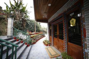 eine Veranda eines Hauses mit Blumen in Töpfen in der Unterkunft Sikkim Tourist Centre in Pelling