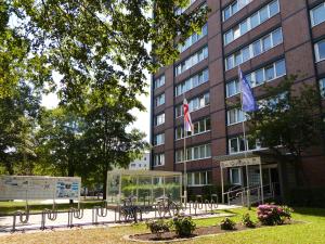 een gebouw met twee vlaggen ervoor bij Hotel & Gästehaus Rostock Lütten Klein in Rostock