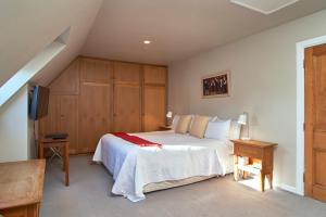 - une chambre avec un lit blanc et des placards en bois dans l'établissement Orari Boutique Hotel, à Christchurch