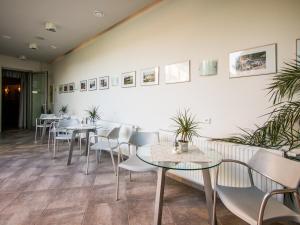 a restaurant with tables and chairs and pictures on the wall at Hotel Krystal in Luhačovice