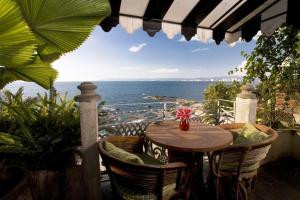 a table and chairs on a balcony with a view of the ocean at Quinta Maria Cortez in Puerto Vallarta