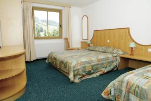 een hotelkamer met 2 bedden en een raam bij Vitranc Apartments in Kranjska Gora