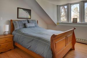 a bedroom with a bed with a wooden frame and windows at Our Space the Perfect Place B&B in Picton