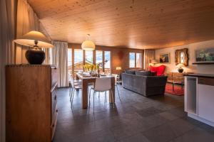 een keuken en een woonkamer met een tafel en een bank bij Chalet Bella Vista 4 in Wengen