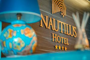 ein Schild für ein Nautilus-Hotel neben einem Zimmer in der Unterkunft Nautilus Hotel in Giardini-Naxos