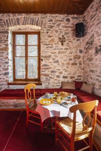 uma sala de jantar com uma mesa com comida em Archontiko Montana em Vizitsa