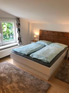 - une chambre avec un grand lit et une tête de lit en bois dans l'établissement Apartment 5, à Wyk auf Föhr