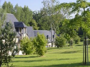 uma casa no meio de um campo verde em Les Manoirs de Tourgéville em Deauville