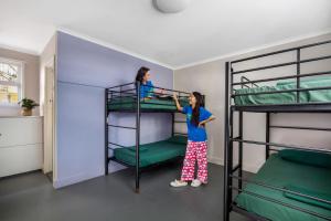 Zwei Mädchen stehen neben einem Etagenbett in der Unterkunft Backpackers In Paradise 18-35 Hostel in Gold Coast