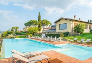 een zwembad met stoelen en een huis bij Borgo Divino in Montespertoli