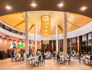 une salle à manger avec des tables, des chaises et un lustre dans l'établissement Hotel Sevtopolis Medical & SPA, à Pavel Banya