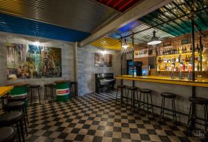 un bar con suelo a cuadros y taburetes en The Yard Hostel, en Catania