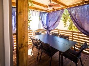 een eetkamer met een tafel en stoelen op een terras bij Mobile Home HappyNest in Biograd na Moru