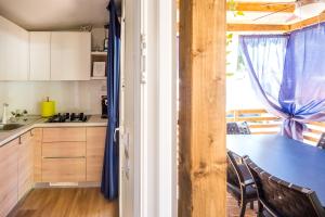 een keuken met een tafel en stoelen en een raam bij Mobile Home HappyNest in Biograd na Moru