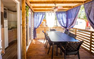 een eetkamer met een tafel en stoelen op een balkon bij Mobile Home HappyNest in Biograd na Moru