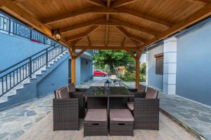 a patio with a table and chairs under a wooden roof at Katerina Rooms & Apartments in Skala Potamias