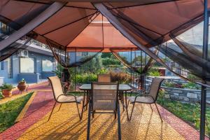 a patio with a table and chairs under a tent at Katerina Rooms & Apartments in Skala Potamias