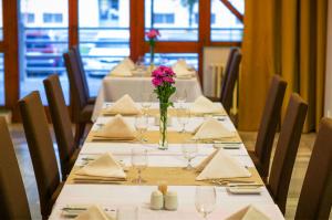 een lange tafel met glazen en een vaas met bloemen bij Hotel Metropol in Spišská Nová Ves